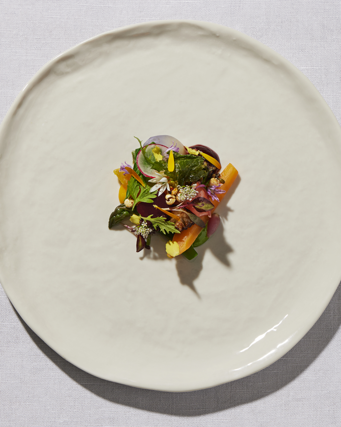 Summer salad with edible flowers and herbs served in the restaurant at Gravetye Manor West Sussex.