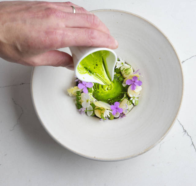 White asparagus with hollandaise and herbs on fine China. Seasonal starter at Gravetye Manor restaurant.